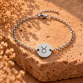 Silver Taurus bracelet with round pendant and linked chain, zodiac bull symbol.