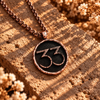Rose-gold-tone Expedition 33 necklace with raised 33 numerals and a distressed circular border.
