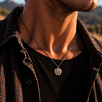 Silver-toned pendant necklace on chest with mythosaur medallion charm