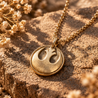 Gold-tone Rebel Alliance medallion necklace with a textured surface and circular border on stone.