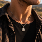 Gold-tone Rebel Alliance necklace worn with a white top in sunlight.