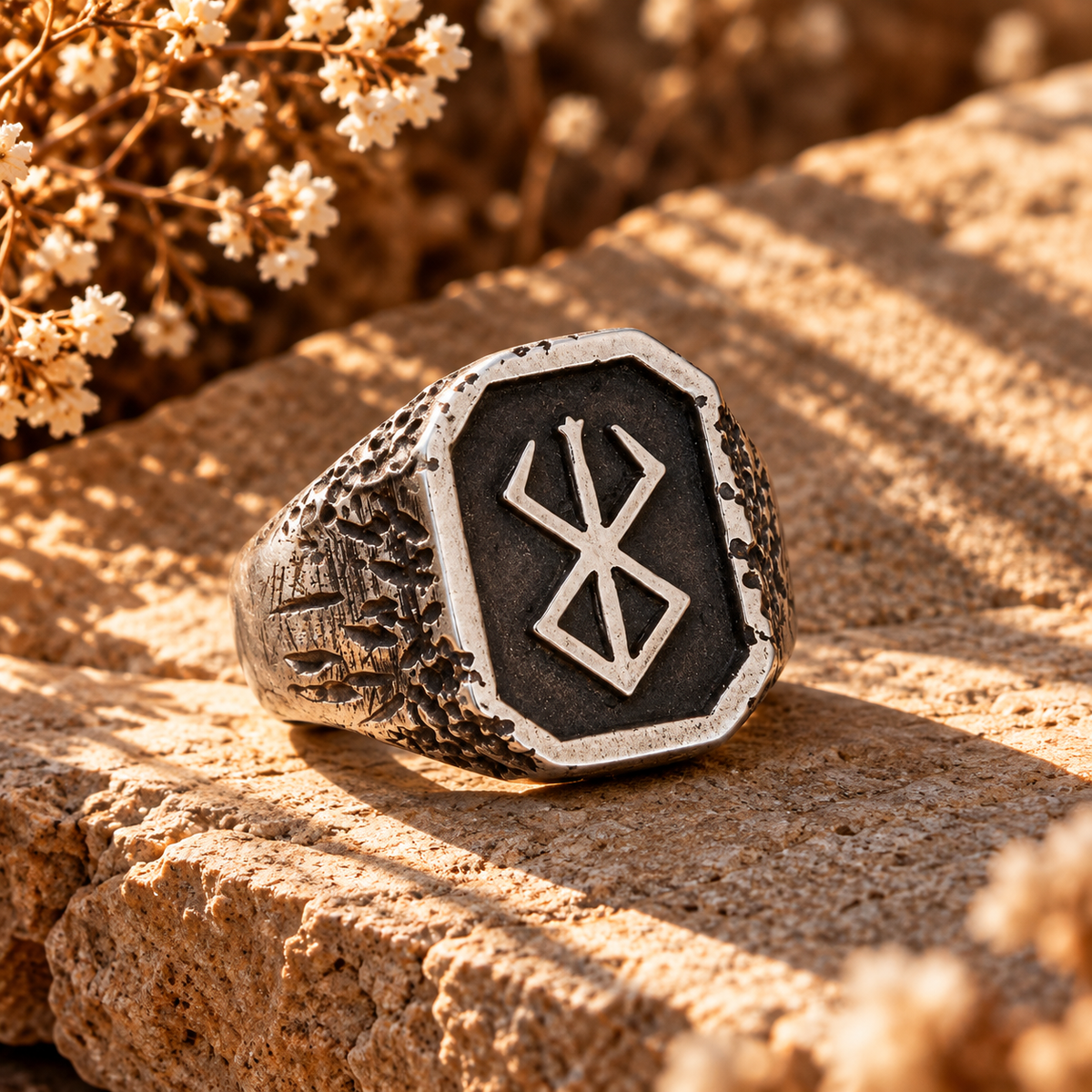 Silver rune signet ring with dark inlay and raised runic symbol.